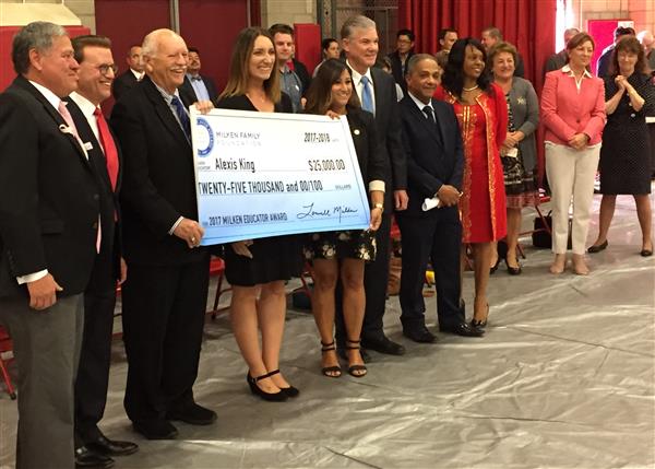 Eight adults holding up a big check for $25,000